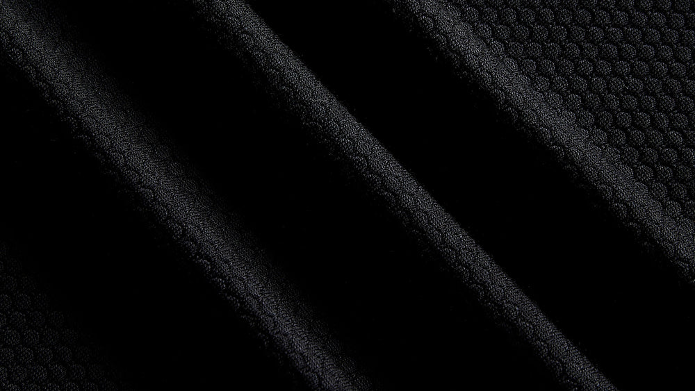 Close up of black merino and Tencel open knit training fabric